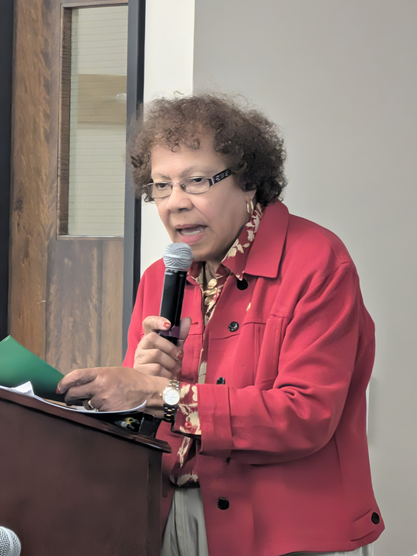 Community elder speaking at the podium during the Trenton Transformation meeting